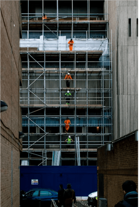 Scaffolders working on a multi-storey scaffold between two buildings